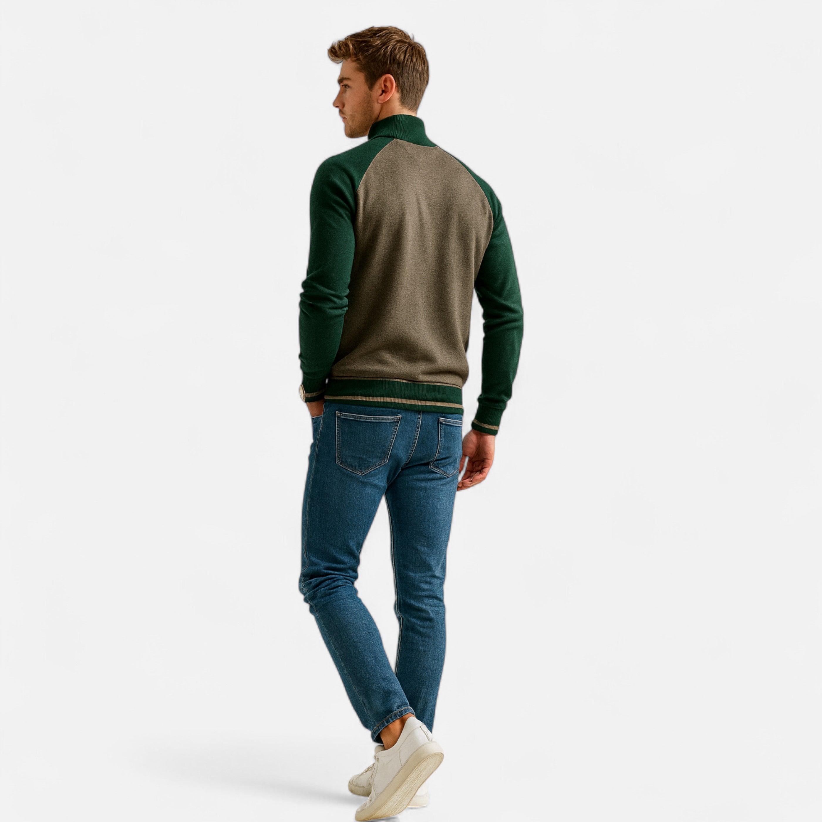 Man wearing a green and brown sweater with blue jeans on a white background