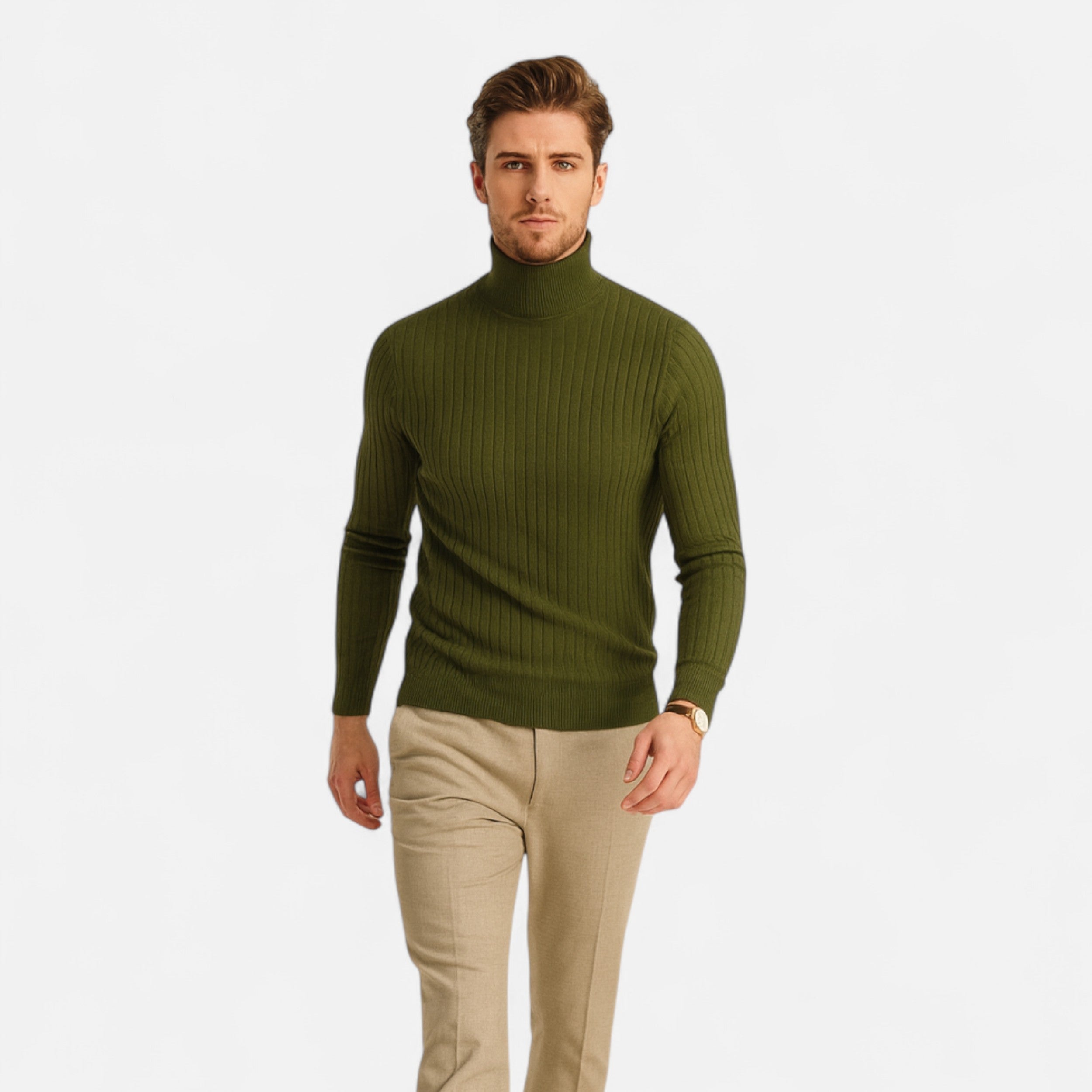 Man wearing a green turtleneck sweater and beige pants on a light gray background