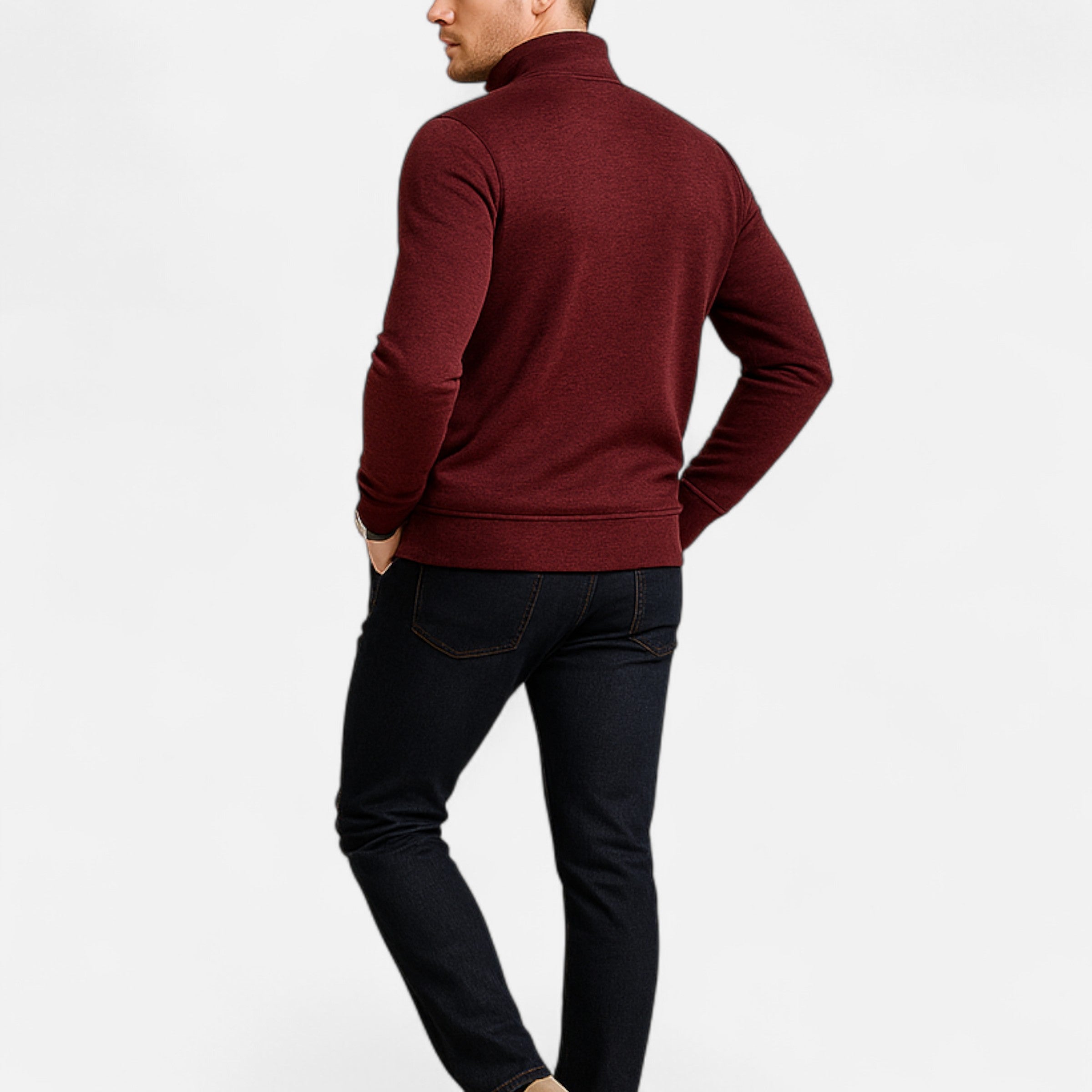 Man wearing a burgundy sweater and dark jeans on a white background
