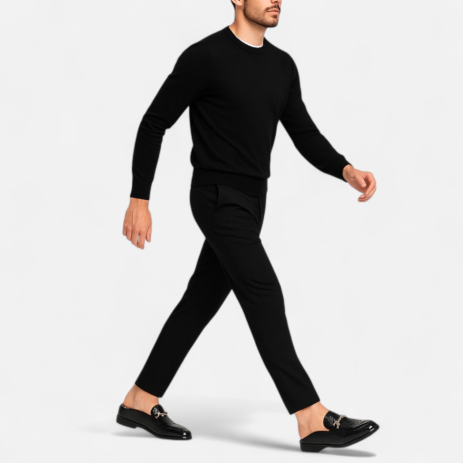 Man wearing a black sweater and pants with black shoes on a white background