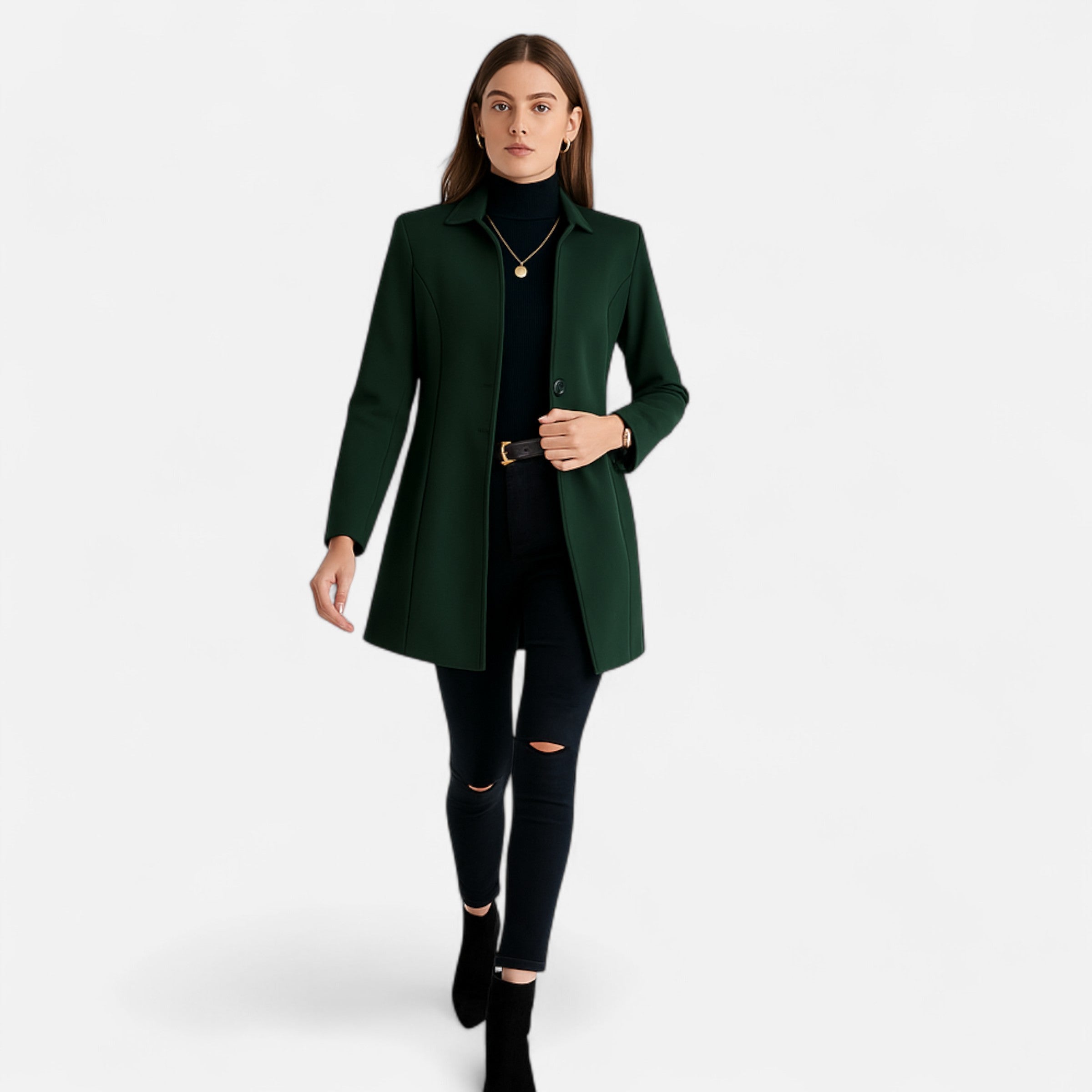 Woman wearing a green coat and black pants on a white background