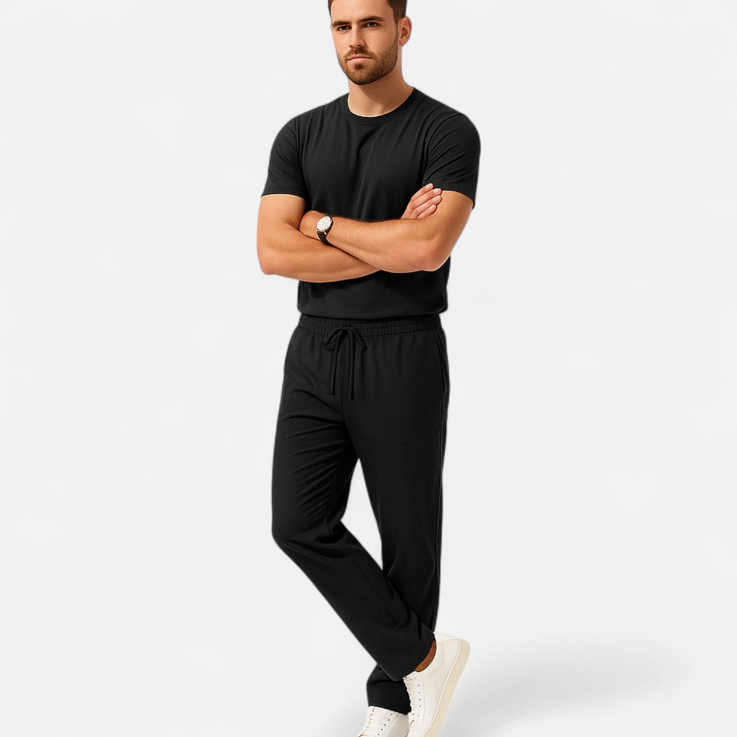 Man wearing a black outfit with white sneakers on a light gray background