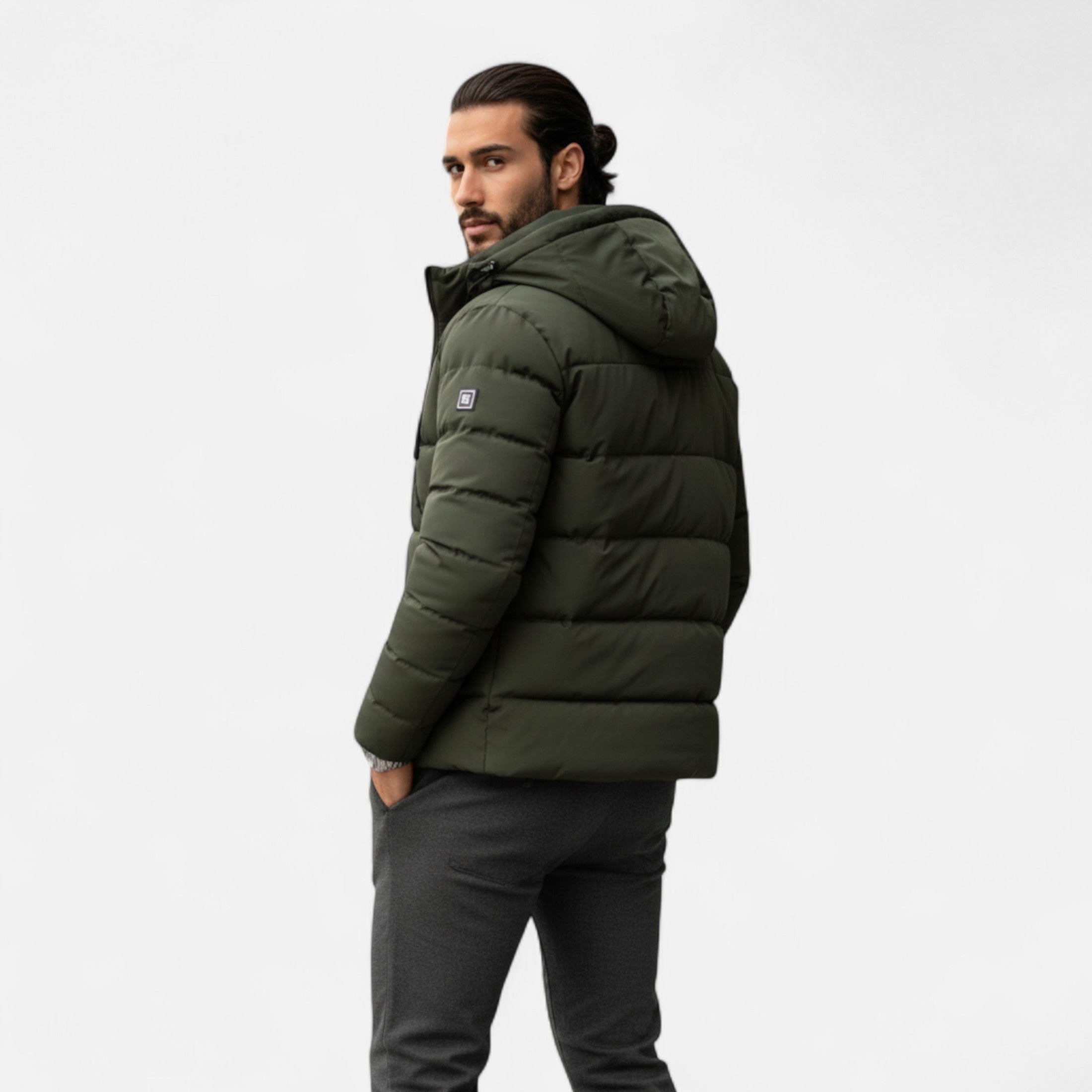 Man wearing a green puffer jacket on a white background
