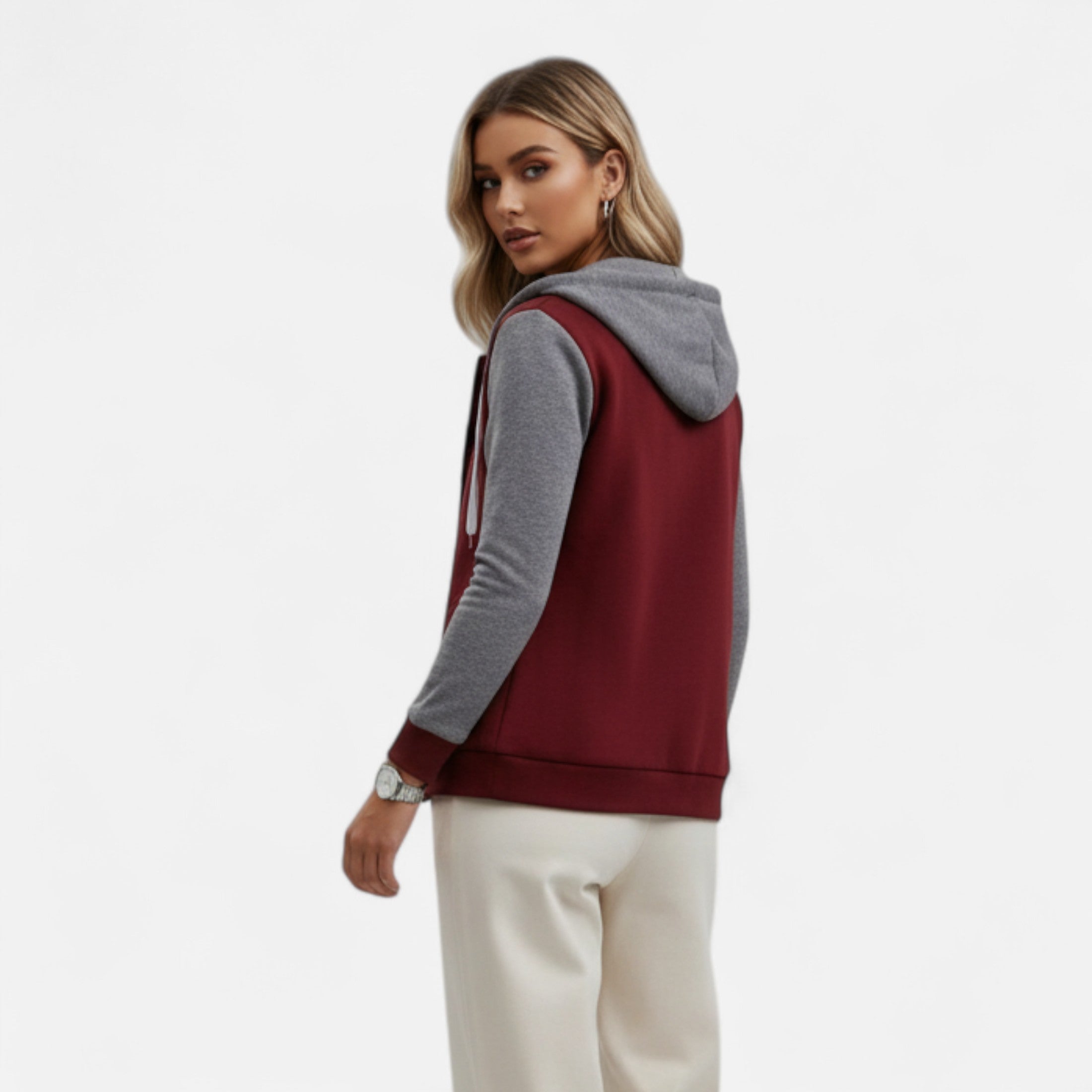 Woman wearing a maroon and gray hoodie on a white background
