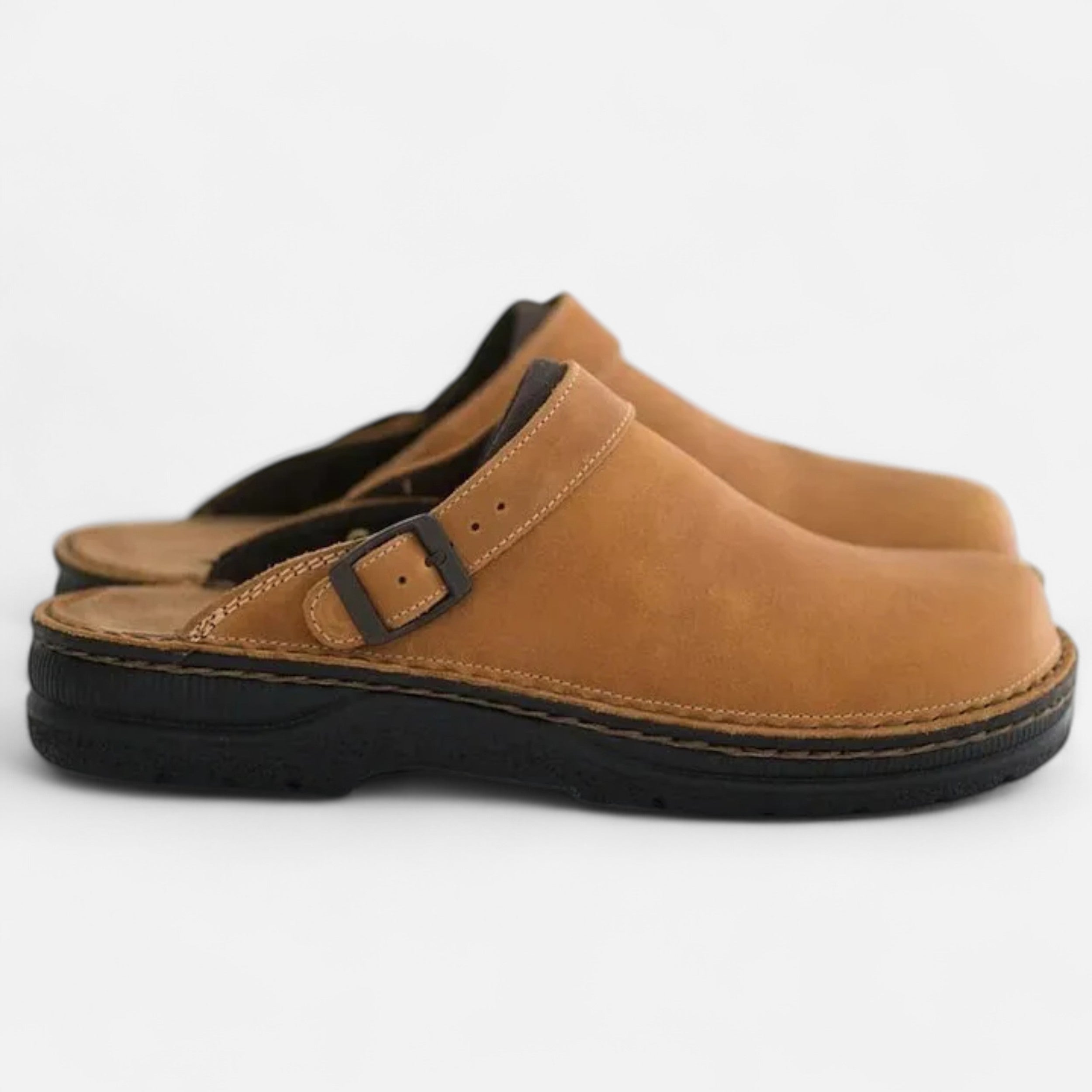 Pair of brown clogs with a buckle on a white background